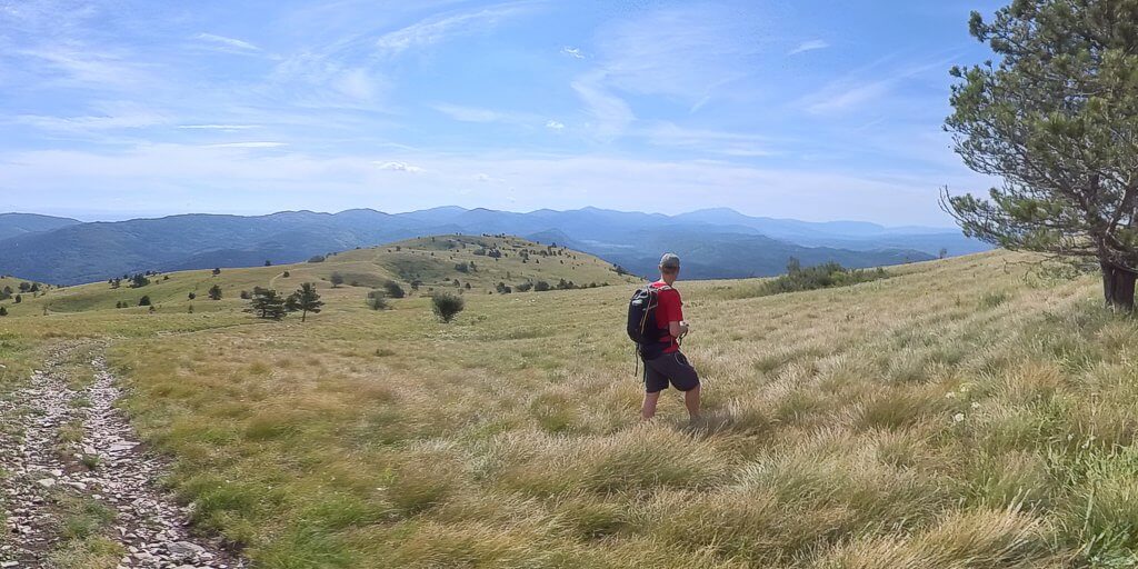 Hiker descending from Žbevnica (1014m) with the Ćićarija laid out ahead, Istria, Croatian Mountains