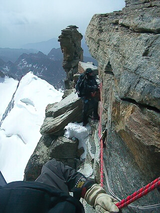 Climbers on the exposed traverse to the Madonna Summit, Gran Paradiso, Italy. © Derek Stillingfleet
